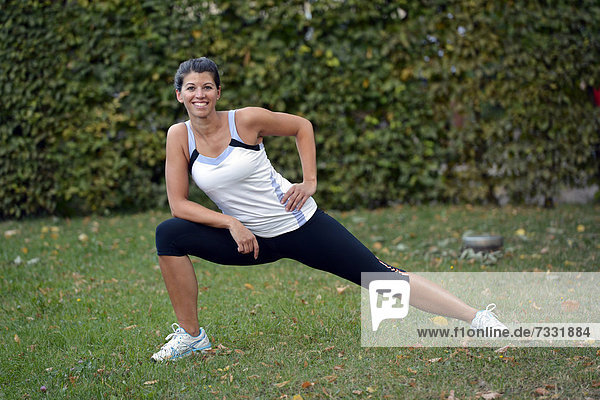 Young woman warming up  stretching exercises  Stuttgart  Baden-Wuerttemberg  Germany  Europe  PublicGround