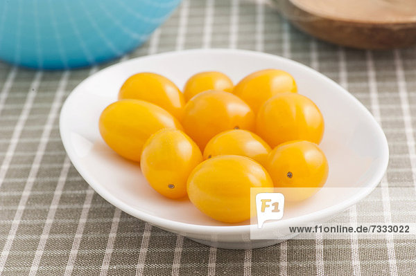 Yellow plum tomatoes on a white plate