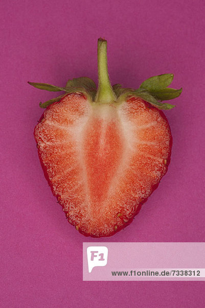 A halved strawberry on a pink background