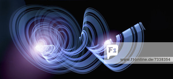Lichtspuren  die ein abstraktes blaues Spiralmuster auf schwarzem Hintergrund erzeugen.