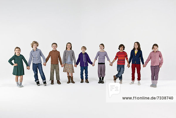 Eine Gruppe von Kindern  die in einer Reihe stehen und Händchen halten.