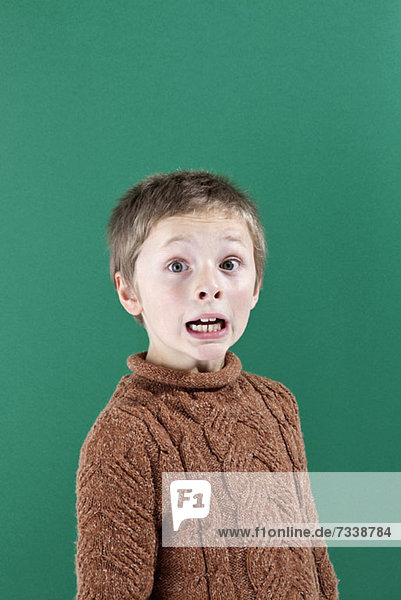 Ein Junge mit einem schockierten Ausdruck von Angst im Gesicht.