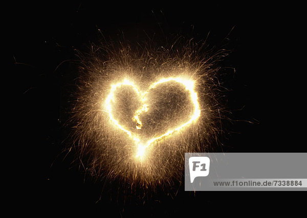 A heart shape drawn with a sparkler against a black background