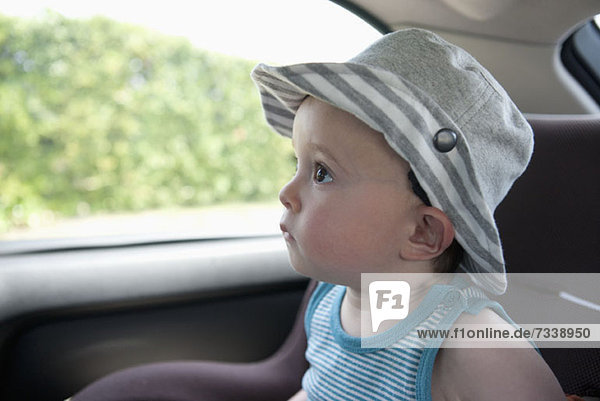Ein Kind  das eine Autofahrt vorwegnimmt  sitzt auf einem Autositz