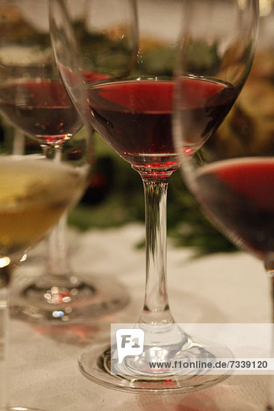Drei Gläser Rotwein und ein Glas Weißwein bei einer Weinprobe  Nahaufnahme