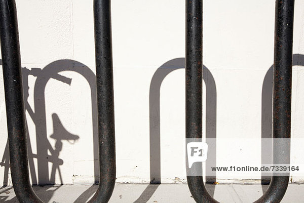 Shadow of bike parked in bicycle stand
