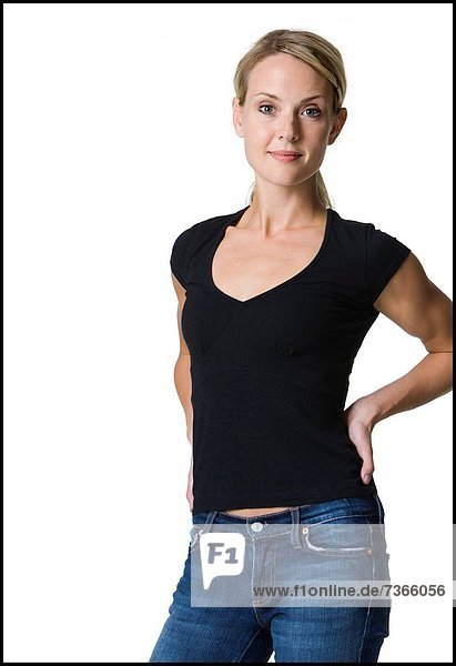 Portrait einer jungen Frau mit ihren Händen hinter ihrem Rücken stehend