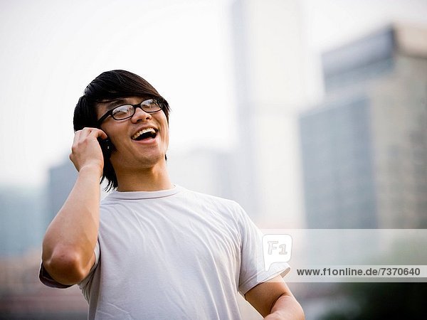 Man with eyeglasses talking on cell phone outdoors smiling