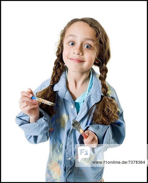Portrait of a girl holding two paintbrushes