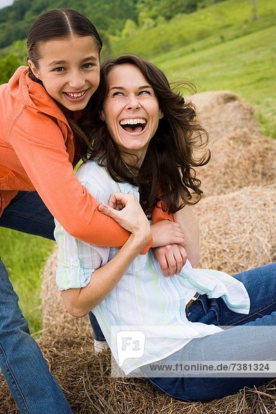 Portrait of a girl hugging her mother from behind