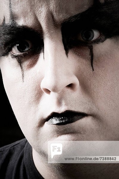 Close_up of man with black and white makeup