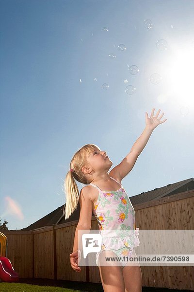Außenaufnahme  fangen  Badeanzug  Himmel  Blase  Blasen  blau  Mädchen  freie Natur