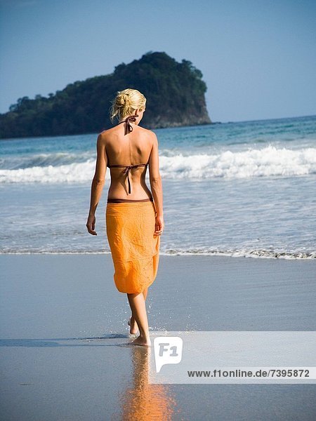 Frau läuft am Strand entlang