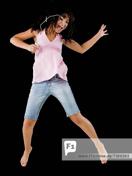 Woman with mp3 player leaping and smiling