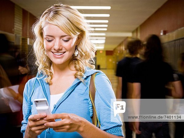 High School girl at school text messaging.