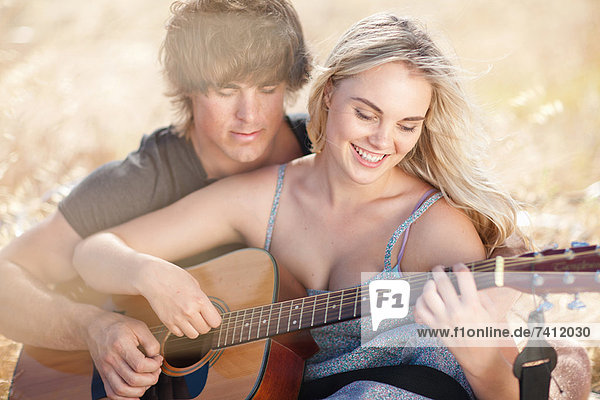 Paare spielen Gitarre zusammen