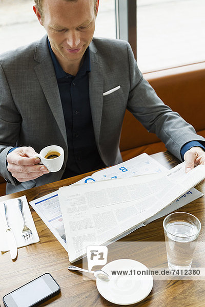 Geschäftsmann beim Lesen im Café
