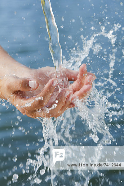 Woman catching water stream in hands