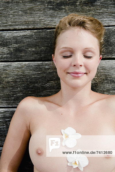 Nude woman laying on wooden deck