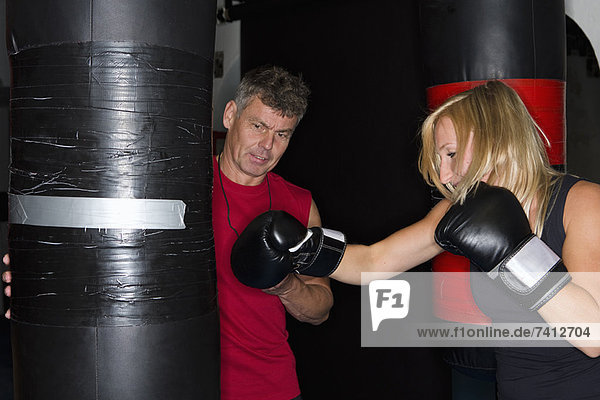 Boxer bei der Arbeit mit dem Trainer im Fitnessstudio