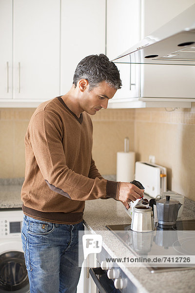 Man making coffee in kitchen