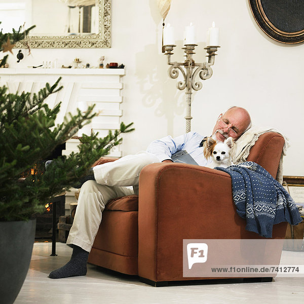 Älterer Mann schläft am Weihnachtsbaum
