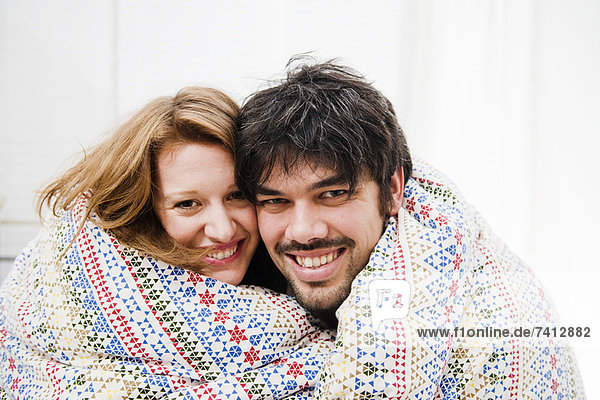 Lächelndes Paar in Decke gehüllt