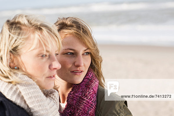 Frauen stehen zusammen am Strand