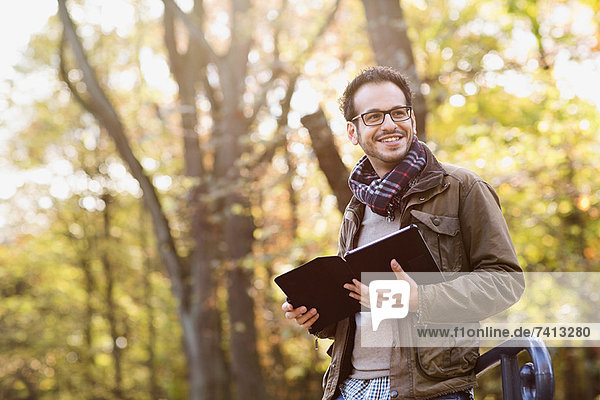 Man using tablet computer in forest