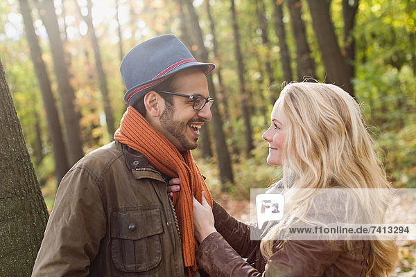 Lächelndes Paar beim Reden im Wald