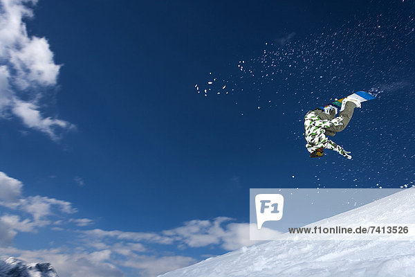 Snowboarder jumping on snowy slope