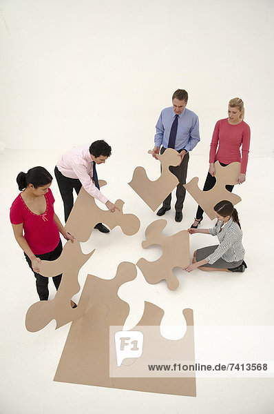 Geschäftsleute beim Zusammenstellen von Puzzlespielen