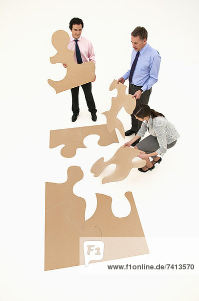 Geschäftsleute beim Zusammenstellen von Puzzlespielen
