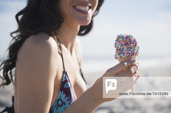 Woman eating icecream on beach