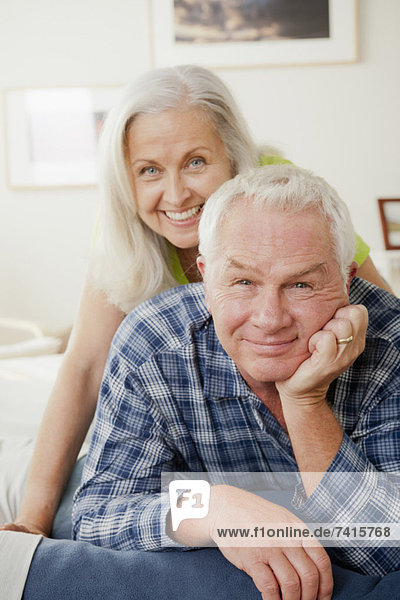 Portrait of senior couple laying on bed