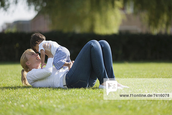 Mother with baby (6-11 months) playing on grass