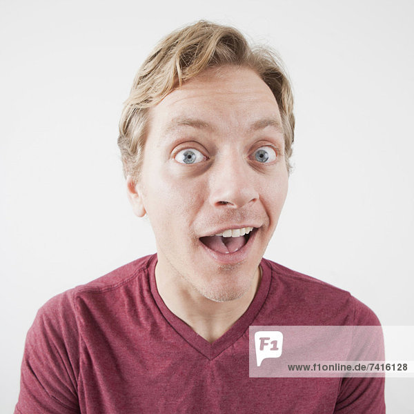 Studio Shot of mid adult man expressing surprise with eyes wide open