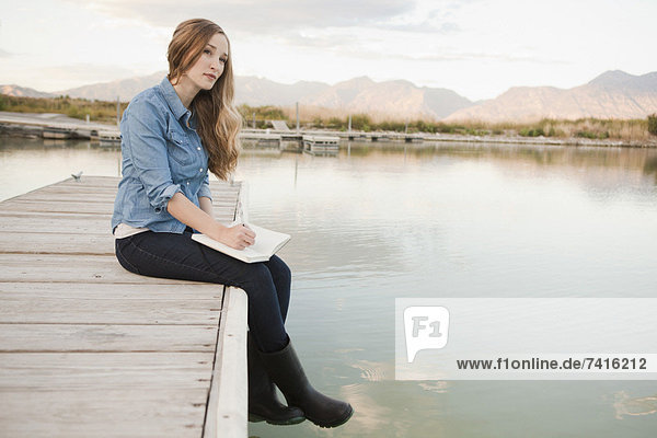 Portrait of young woman sitting on jetty