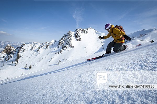 One male telemark skier skiing by.