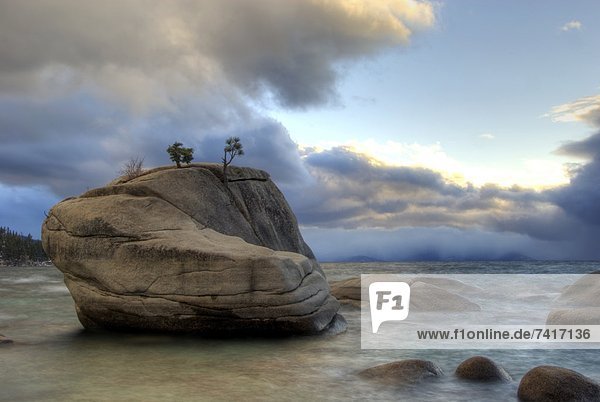 Dramatic clouds and light frame Bonsai Rock on the east shore of Lake Tahoe  NV.