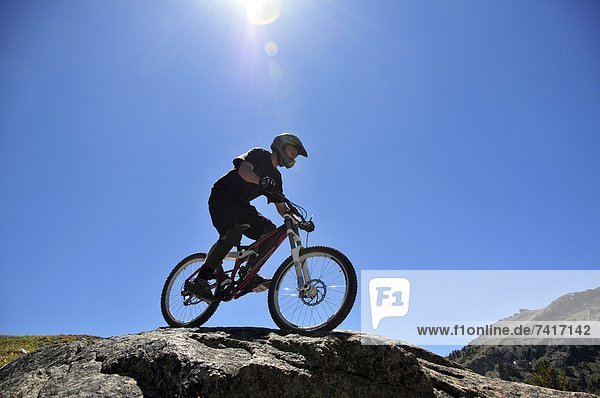 A mountain biker rides down a technical section of rock at Kirkwood Mountain Resort in the summer  CA.