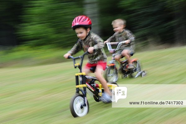 Two boys riding bikes.