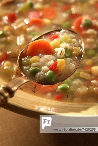 Spoonful of Barley Soup Over a Bowl