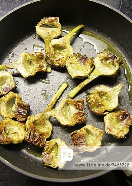 Fried artichoke hearts in a pan
