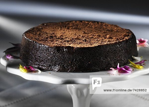 A chocolate truffle cake on a cake stand