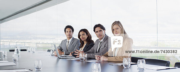 Portrait von selbstbewussten Geschäftsleuten am Tisch im Konferenzraum