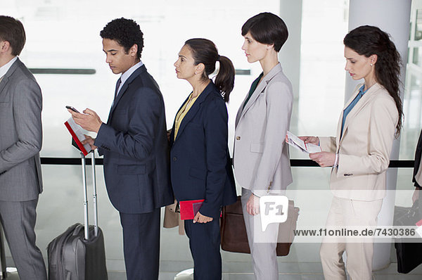 Business people standing in queue at airport