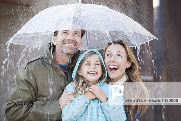 Enthusiastische Familie im Regenschauer