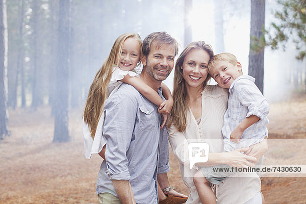 Porträt einer lächelnden Familie im Wald