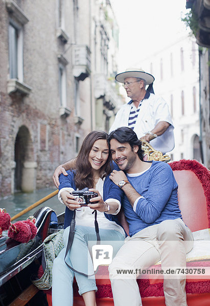 Lächelndes Paar beim Selbstporträt mit Digitalkamera in der Gondel auf dem Kanal in Venedig
